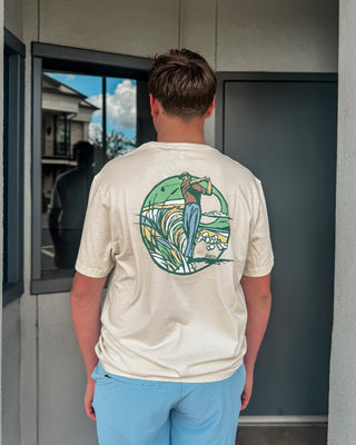 Person wearing a t-shirt with a colorful graphic on the back, standing in front of a door.